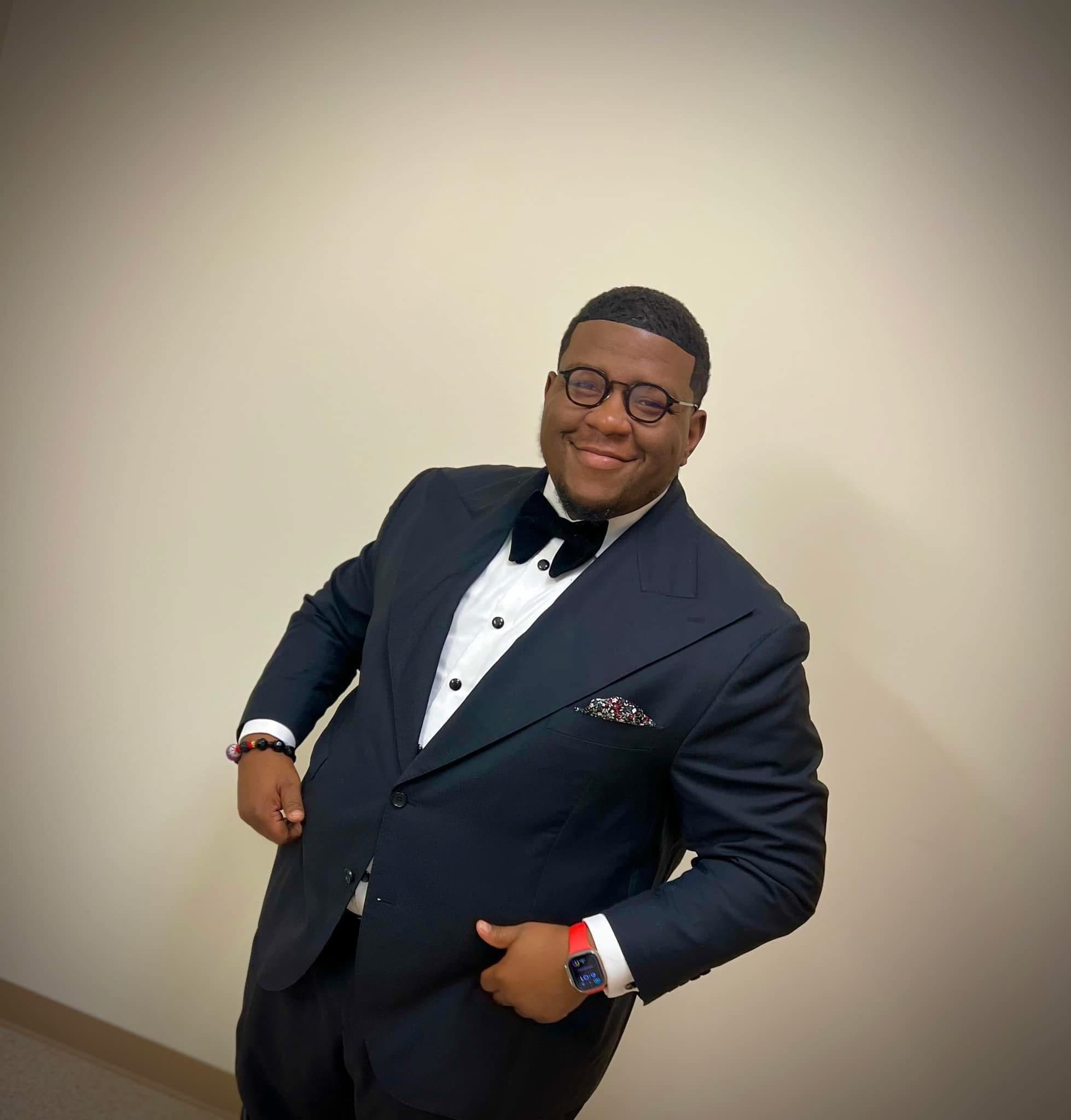 Overseer Jakeem Bowman in a black tuxedo and velvet bow tie